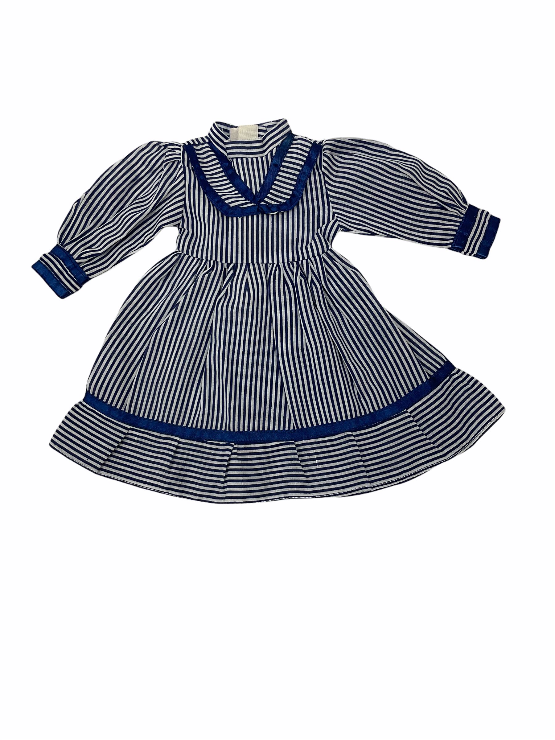 Heidi Ott doll in tartan dress, navy floral dress with white lace and ribbon detailing, striped blue and white dress and a 'Head to Toe' book