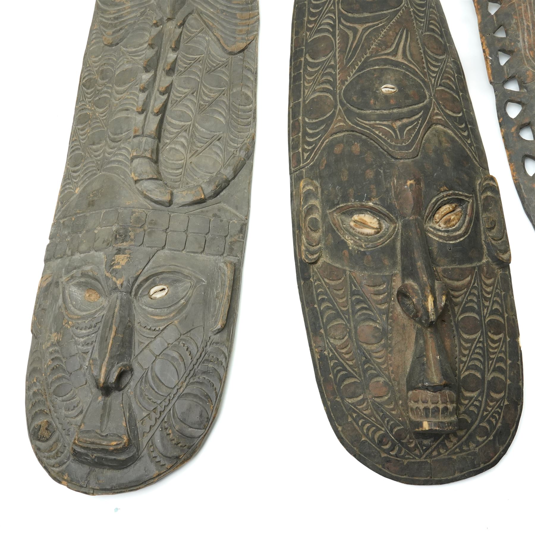 Papua New Guinea Middle Sepik carved sago plate with crocodile head handle L81cm, two Sepik masks/wall hangings inset with cowrie shells, larger 90cm and a small mask (4)