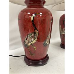 Pair of large table lamps of tapering form, decorated with cranes upon a red ground, upon circular footed base, H68cm