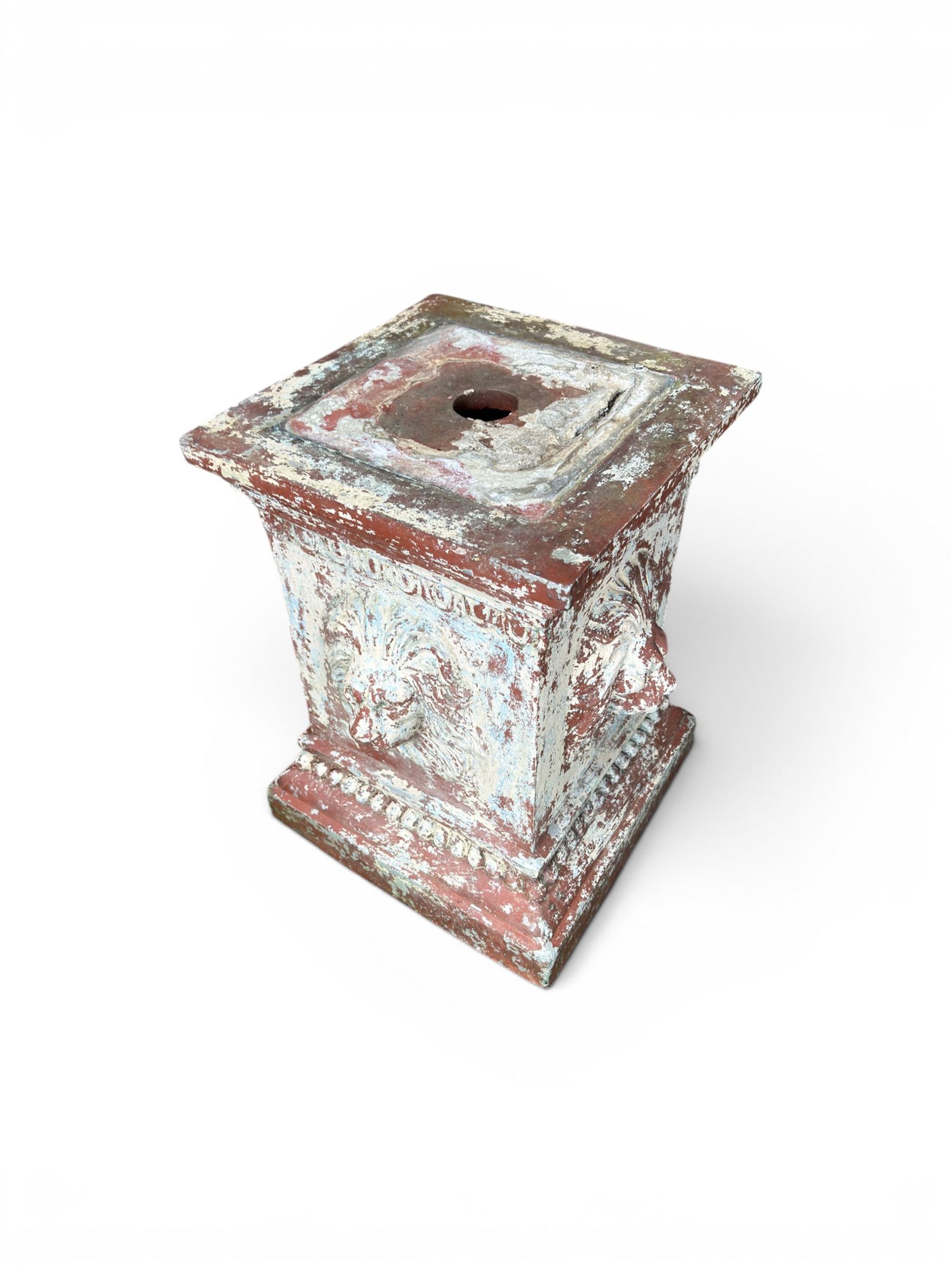 Early 20th century terracotta pedestal, square form with egg and dart detail, four lions masks to either side, finished in distressed cream paint