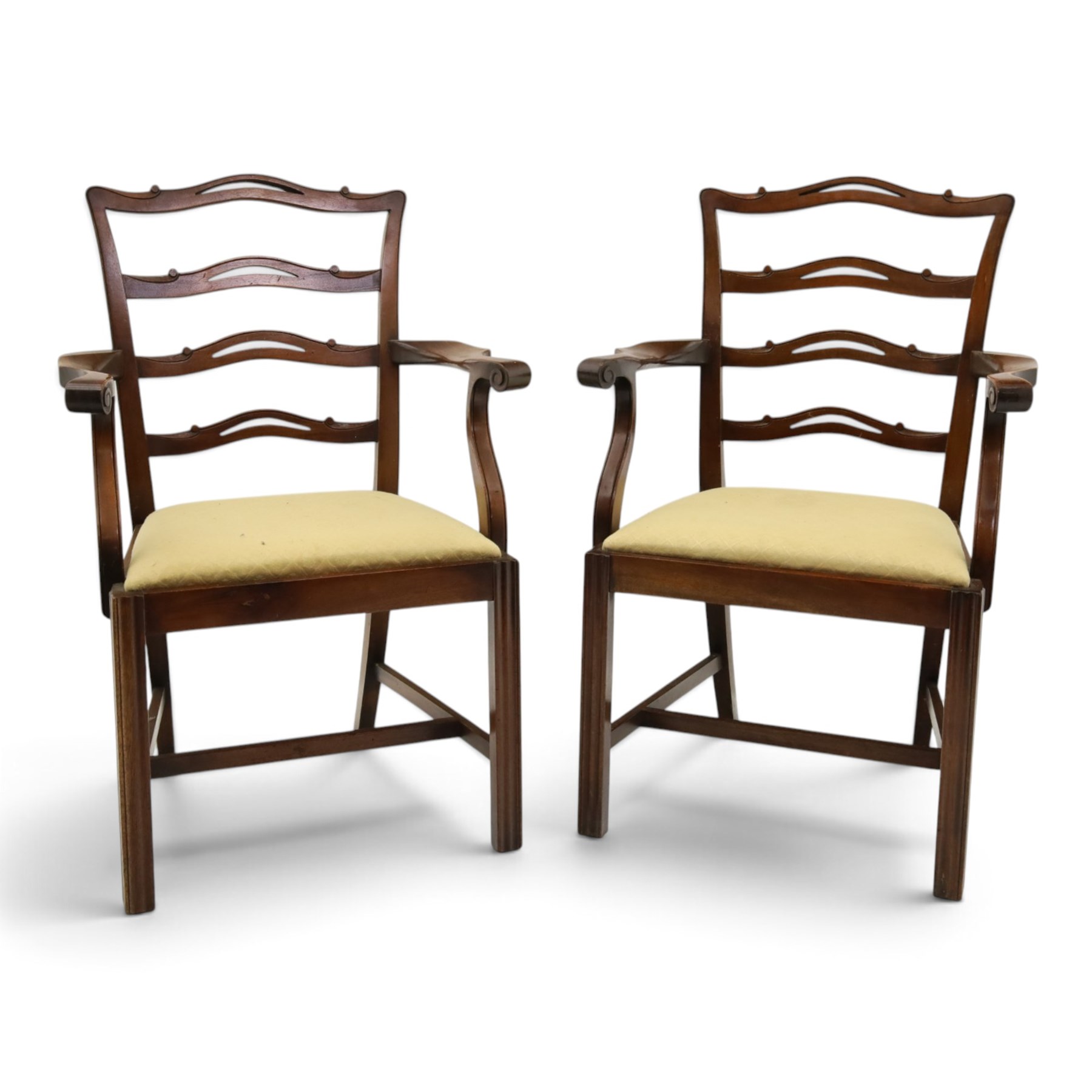 Pair of Georgian design Chippendale style mahogany elbow chairs, the pierced and waived ribbon ladder-back over scrolled arm terminals and yellow drop-in seats, on moulded and chamfered square supports