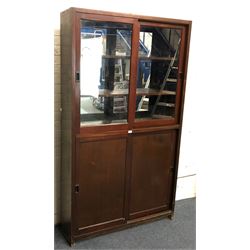 20th century pine mirror back display cabinet with sliding glass doors revealing two shelves, above solid sliding doors revealing fitted interior, platform base 