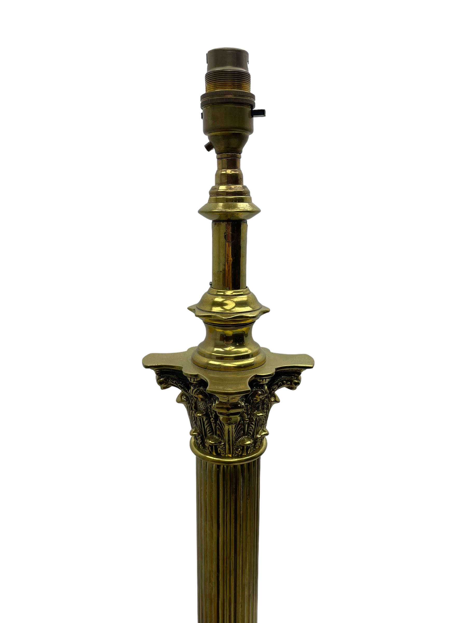 Late 20th century brass telescopic standard lamp in the form of a Corinthian column, Corinthian acanthus leaf capital over reeded shaft, stepped and moulded square base with four extending ball and claw feet