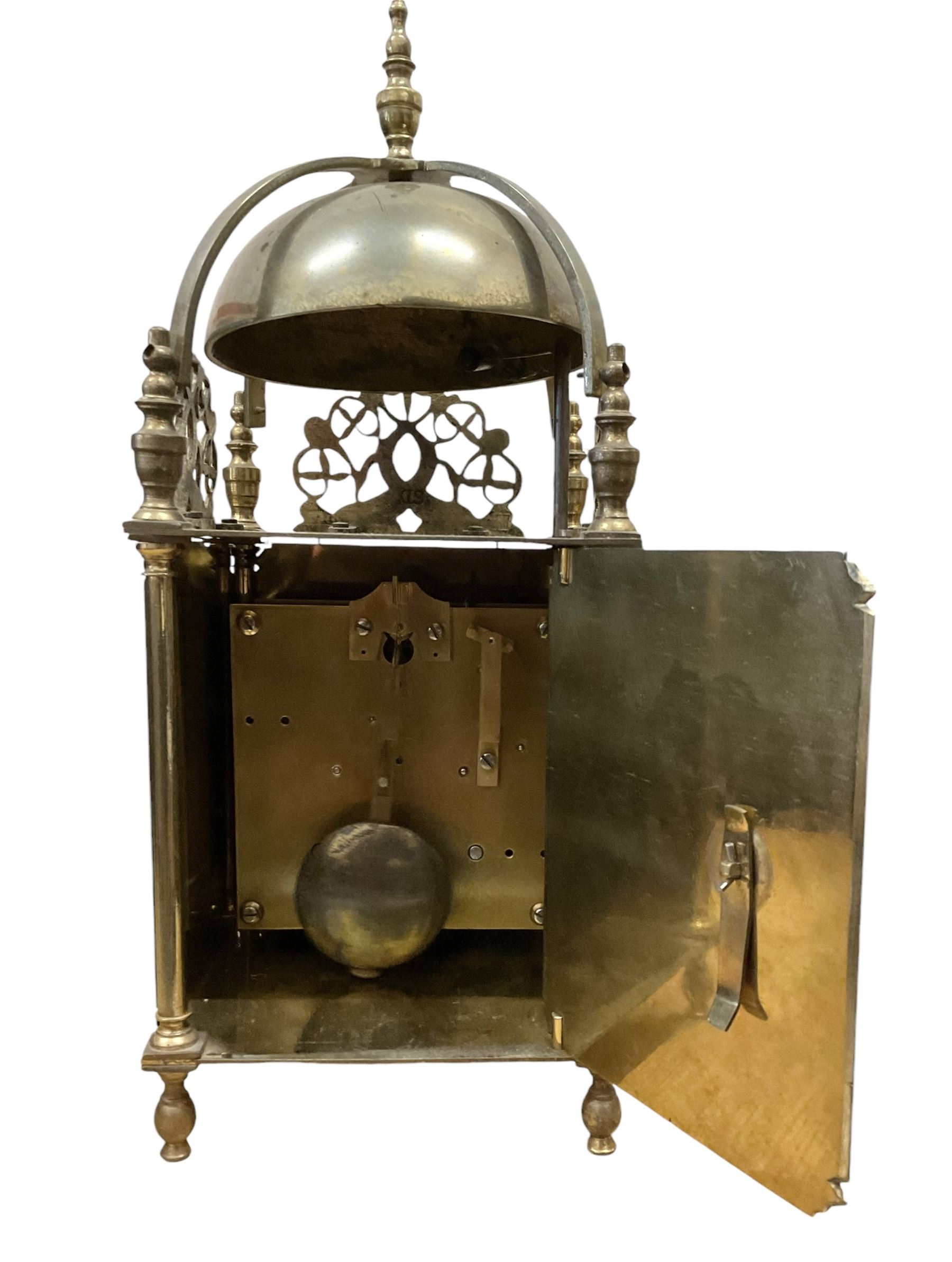 English - 20th century 8-day lantern clock in period 18th century style, square brass case surmounted by a domed bell, with a brass chapter, engraved dial centre and stylised period steel hands, with a two train spring driven movement striking the hours and half hours on a bell. With pendulum. 