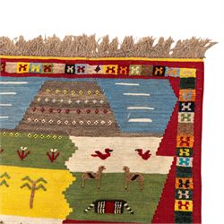 South West Persian Qashqai kilim, the field arranged with stepped polychrome panels depicting stylised camels, goats, cattle and birds, interspersed with trees and flowering stems, enclosed by a red border with multicoloured geometric devices