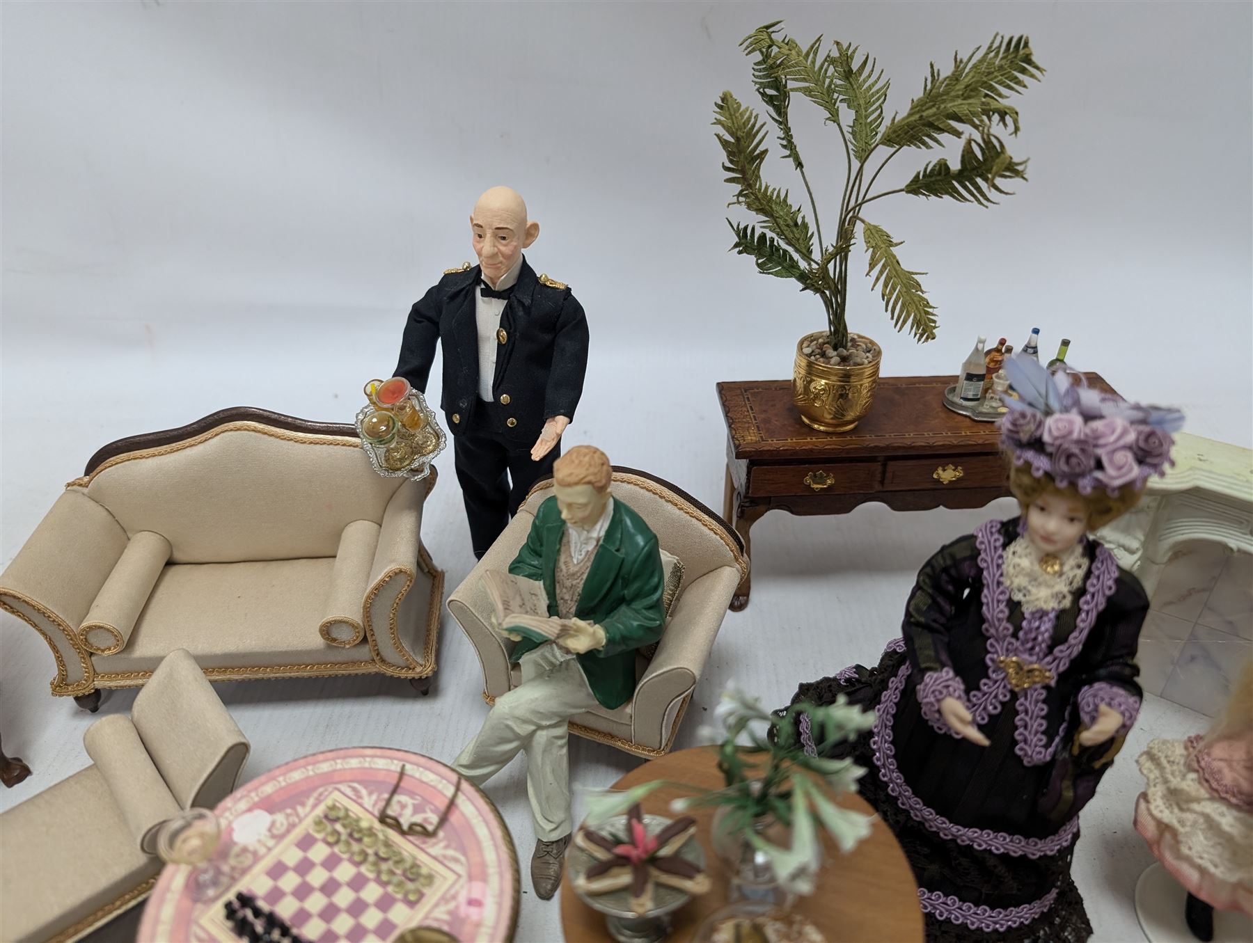 Dolls house furniture, including sofa, chairs, foot stools, fireplace, sideboards, five figures, mirrors, paintings and accessories