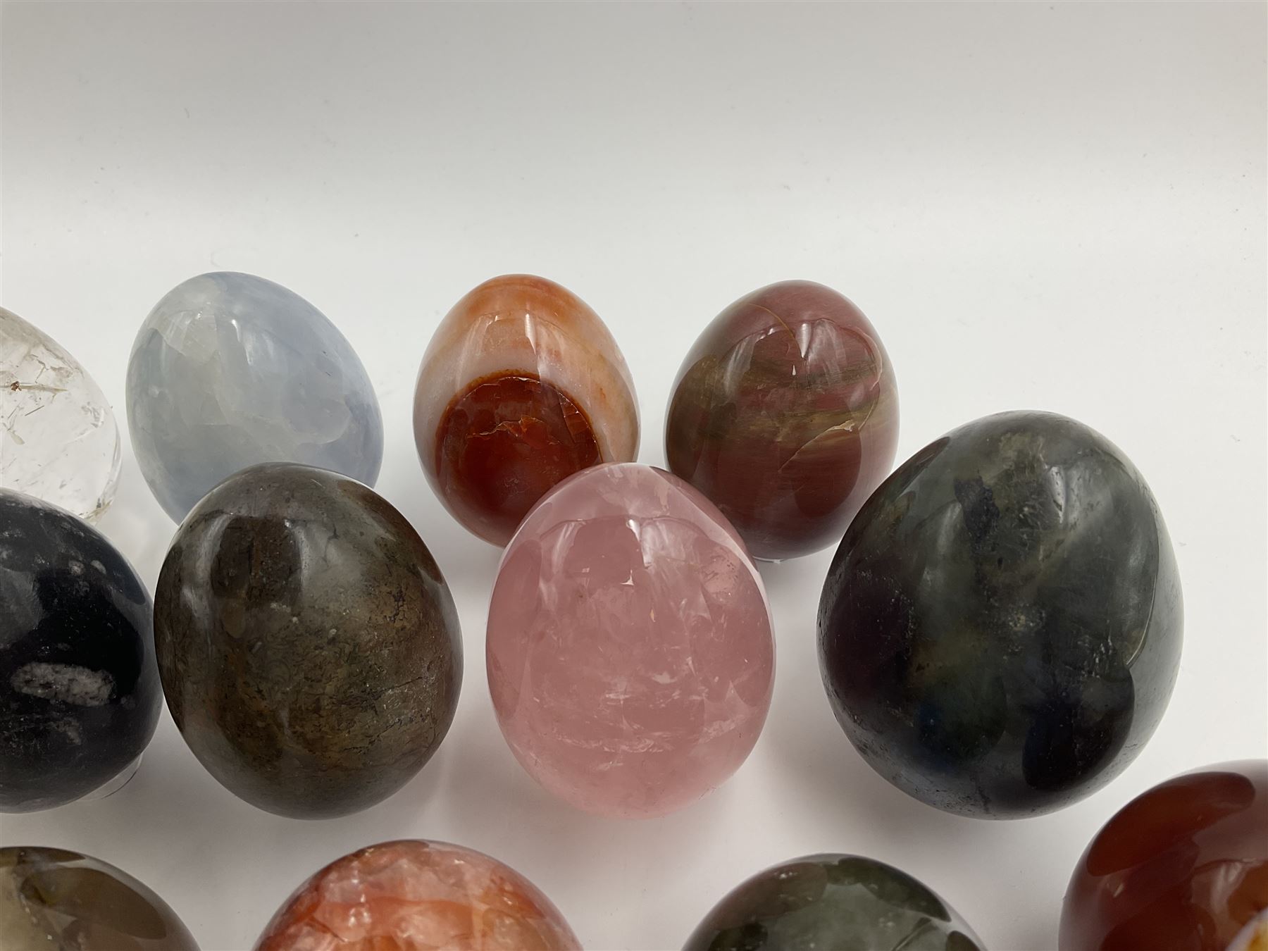 Collection of twenty-one hardstone specimen eggs, including labradorite, calcite, orbicular jasper, tiger's eye, smokey quartz, fossilised wood etc, originally part of the collection of the late Stanley J Seeger