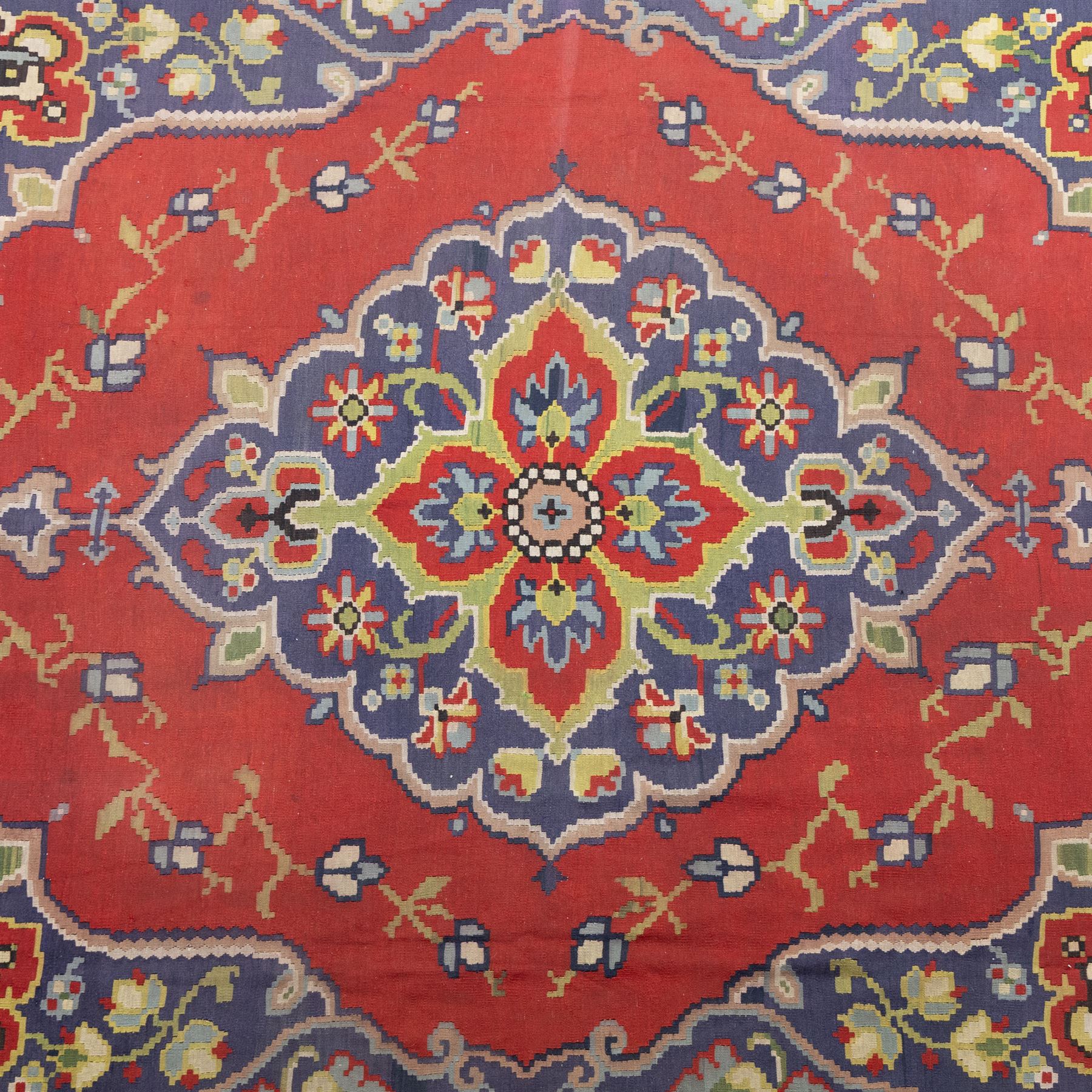Turkish Malatya type flatwoven rug, decorated with a red medallion field, stylised floral motifs and blue corner panels, enclosed by beige foliate border and outer floral guard band