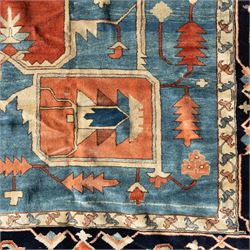 Exceptionally large Northwestern Persian Heriz, hand-knotted carpet, madder red field with a bold stepped medallion in indigo and ivory, and light blue spandrels within a dark indigo border of rosettes and angular vine motifs 




