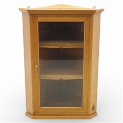 Unicornman - glazed oak corner cabinet, the triangular top with moulded cornice above a bevelled glass door, enclosing two fixed shelves, the canted front corner carved with Unicorn motif, by Geoff Gell of Coxwold