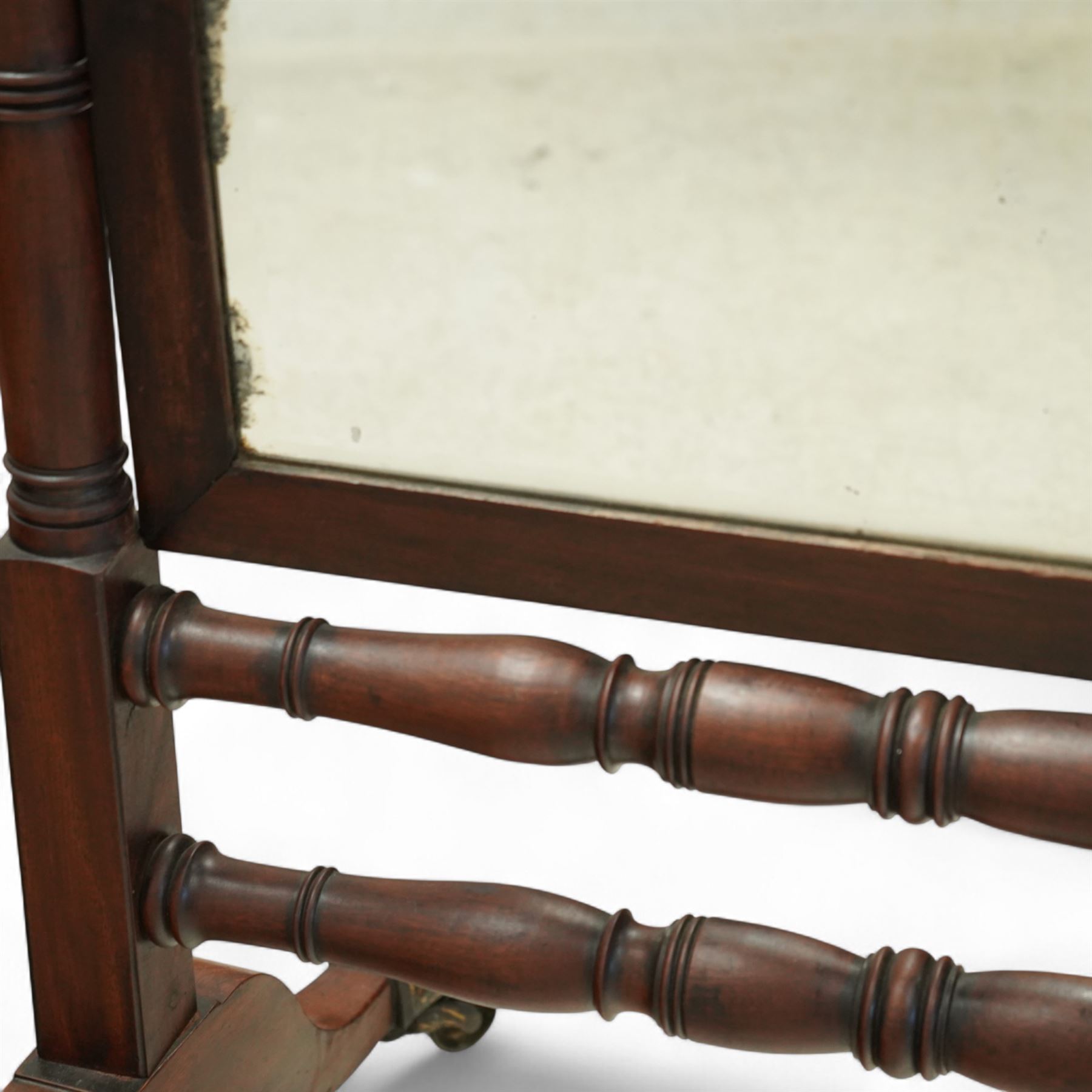 Late 19th-century Regency-style mahogany cheval mirror, rectangular mirror plate within turned uprights and turned cross stretchers supported on down-swept legs terminating in brass paw castors 