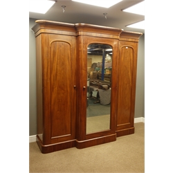  Victorian mahogany triple wardrobe, centre mirror glazed door, two arched panelled doors, fitted with drawers and linen slides, plinth base, W212cm, H208cm, D68cm  