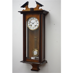 Late 19th century walnut and ebonised Vienna wall clock with broken arched pediment over a single glazed door, the brass and enamel dial with Roman numerals and eight day movement striking on a gong, on ogee base H77cm  