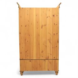 Two contemporary traditional-style wardrobes, projecting plain cornice above two arched moulded panel doors, above a full-width drawer fitted with turned wooden handles, raised on turned bun feet