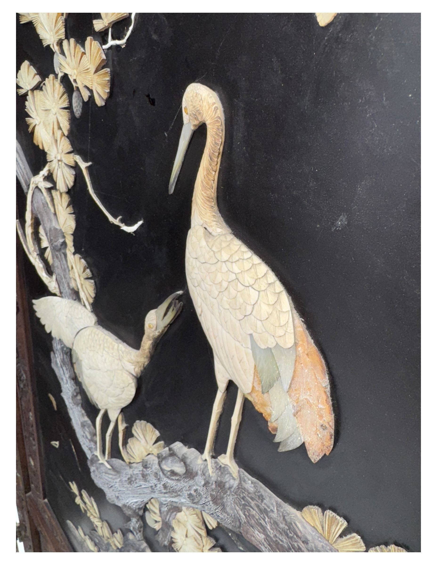 Meiji period (1868–1912), Shibayama lacquer carved hardwood two-fold screen inlaid with mother-of-pearl, bone, and ivory, decorated on one side in high relief and inlaid in a  Shibayama manner with oriental storks flying below flowering branches,  the reverse lacquer panels depicting flowering cherry trees. This item has been registered for sale under section 10 of the APHA Ivory Act.