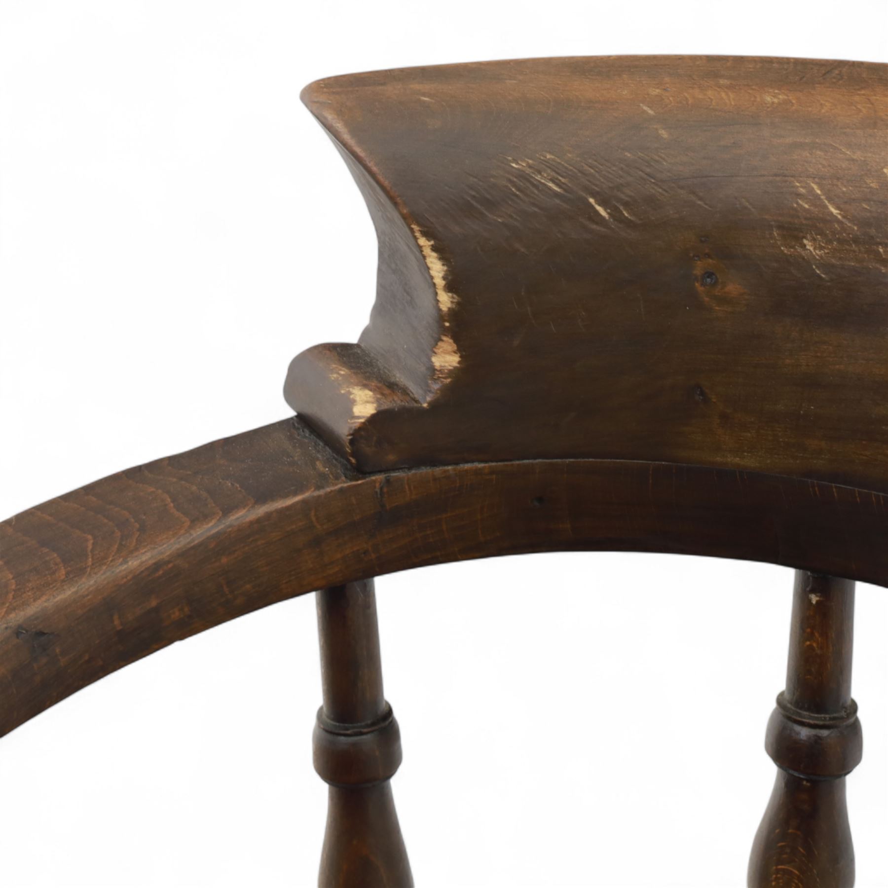 Early 20th century smokers bow armchair, shaped and curved top rail over turned spindles and open arms with rounded terminals, shaped elm seat on turned supports