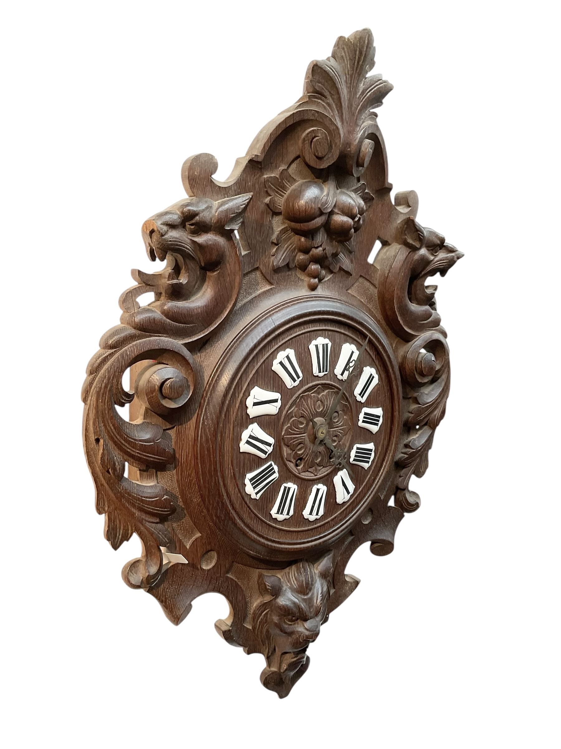 French- late 19th century carved oak wall clock c 1880, outer case with interlaced scroll carving and a carved images of fruit and wild beasts, integrated dial with porcelain cartouche Roman numerals and gothic hands, with a twin train spring driven rack striking movement striking the hours on a coiled gong.
