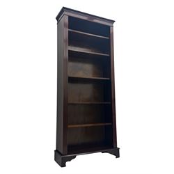 Early 20th century mahogany open bookcase, the rectangular top with dentil moulding, the sides with fluted decoration, fitted with five adjustable shelves, on ogee-moulded bracket supports