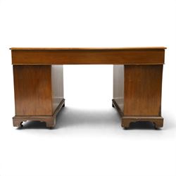 Late Victorian mahogany desk with red leather top, rectangular top with inset toold red leather writing surface, central long frieze drawer flanked by two short drawers, above pedestal with three graduating drawers with ring pull handles, on moulded plinth bases raised on castors