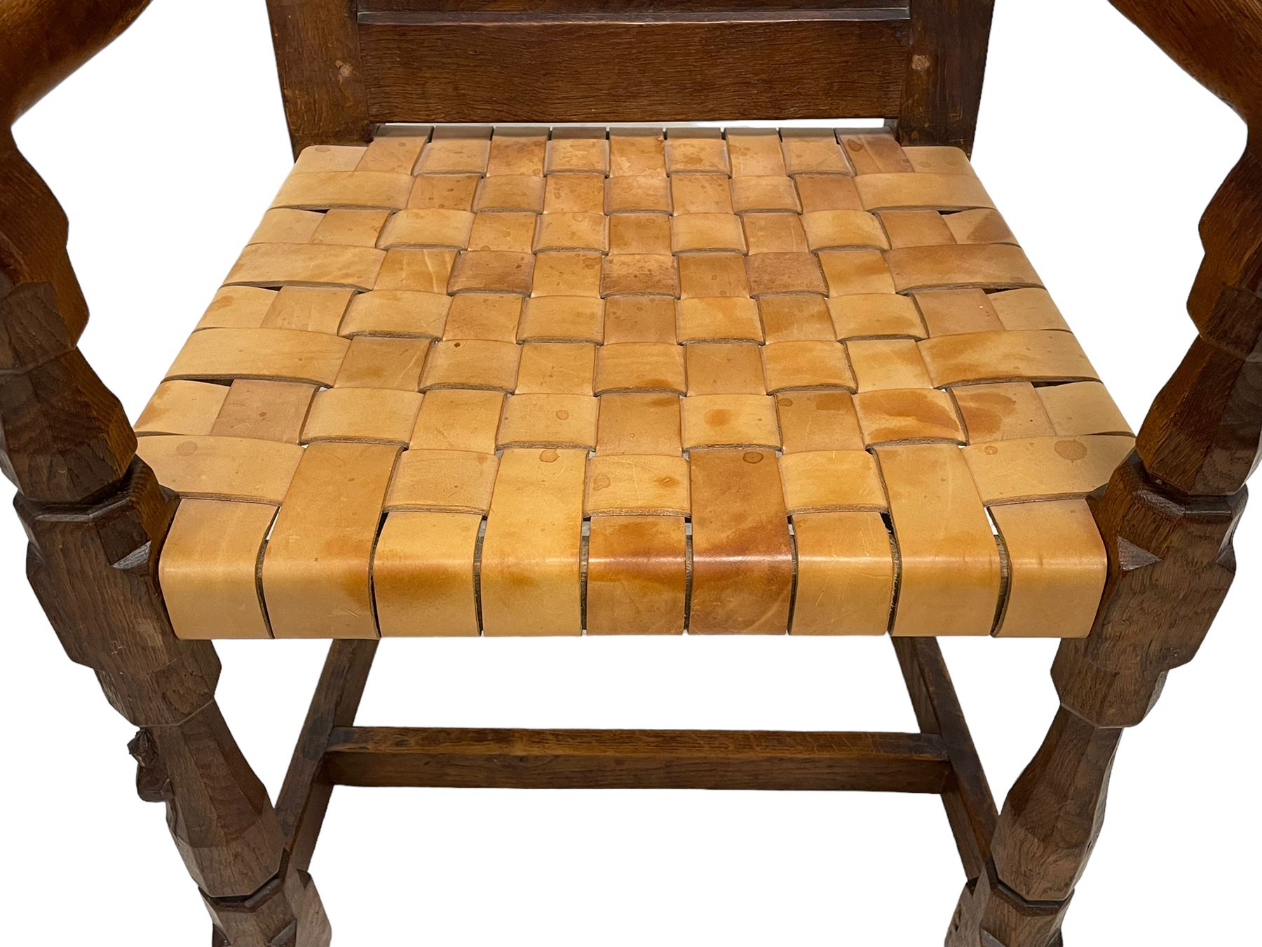 Mouseman - circa. 1930s set of six (4+2) oak dining chairs, panelled back carved with the Bagshawe family crest, the moto 'Forma Flos Fama Flatus' over an arm grasping a bugle-horn with ribbon tie and Yorkshire rose motif, adzed frame, leather lattice strap seat, on octagonal supports united by stretchers, two carvers and four side chairs, each carved with mouse signature, by Robert Thompson of Kilburn 

Provenance: Owned since manufacture by the Bagshawe family, descendants of the Staithes Group Artist Joseph Richard Bagshawe RBA (1870-1909).