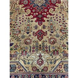 Persian Azarbaijan golden ground carpet, the shaped crimson ground medallion decorated with geometric motifs, the field profusely decorated with stylised plant and flower head motifs, repeating border with guard bands 