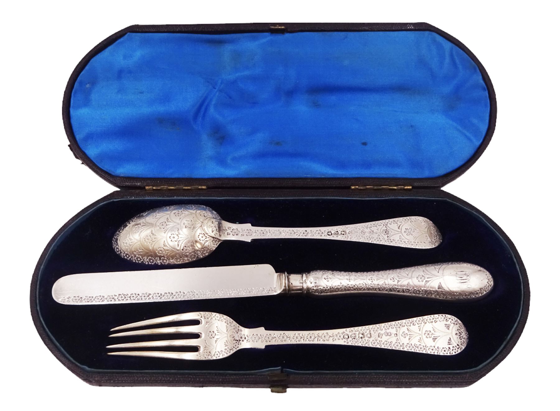 Victorian silver cutlery set, comprising knife, fork and spoon, all profusely engraved with flower heads, each with initials terminals, hallmarked Chawner & Co Birmingham 1877, contained within tooled leather, velvet and silk lined fitted case