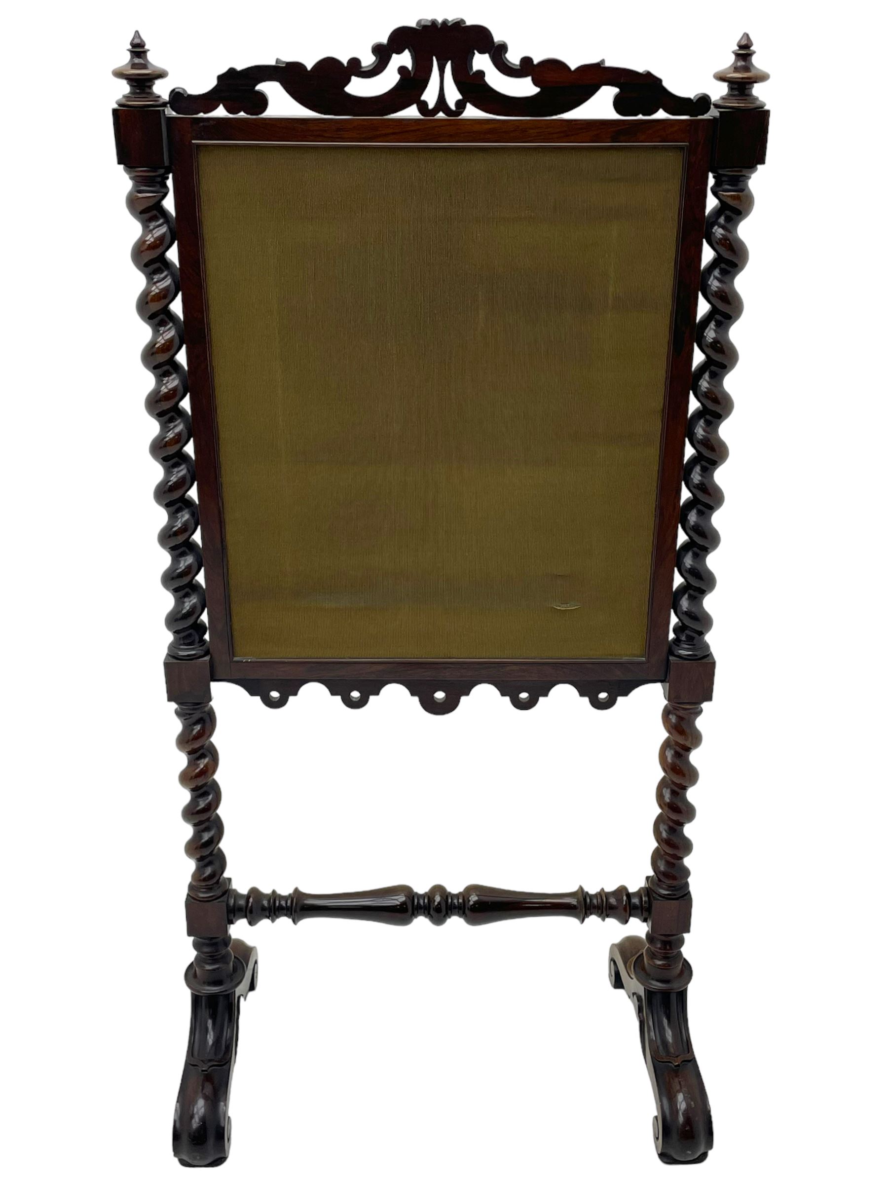 Victorian rosewood fire screen, scrolled foliage carved pediment, rectangular frame with moulded gilt slip enclosing figural needlework tapestry panel, on spiral turned supports with finials united by turned lower stretcher, on out-splayed feet with scroll carved terminals 