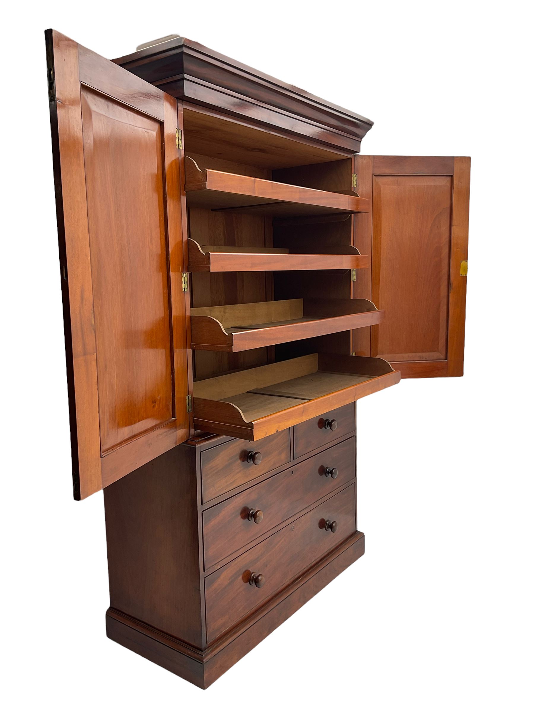 Victorian mahogany linen press, projecting moulded cornice, two doors with arched panels enclosed four linen slides, the lower section fitted with two short and two long drawers, on plinth base