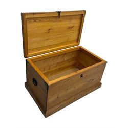 Contemporary polished pine blanket chest, the hinged planked lid with iron strap hinges and clasp fitting, plain boarded sides, fitted with blackened metal drop handles, on a moulded plinth base