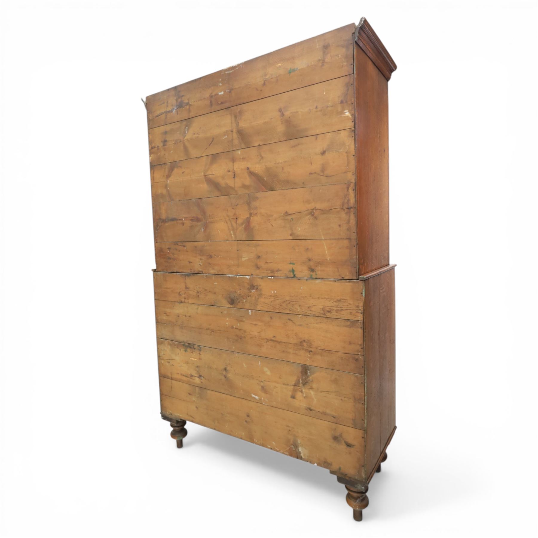 Late 19th century country oak cupboard on chest, cornice top above twin recessed panel doors with central escutcheons, flanked by turned pilasters, the lower chest with two short and three long drawers fitted with turned knob handles, on turned feet