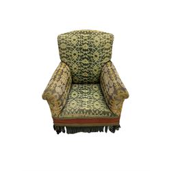 Early 20th century armchair, upholstered in green patterned fabric with sprung seat and fringe, raised on tapered supports with castors
