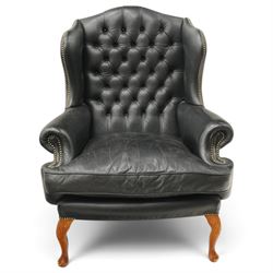 Pair of quality Georgian design wingback club armchairs, the high arched back with wings over rolled arms, upholstered in back-buttoned black leather with loose seat cushion, raised on foliate carved cabriole supports