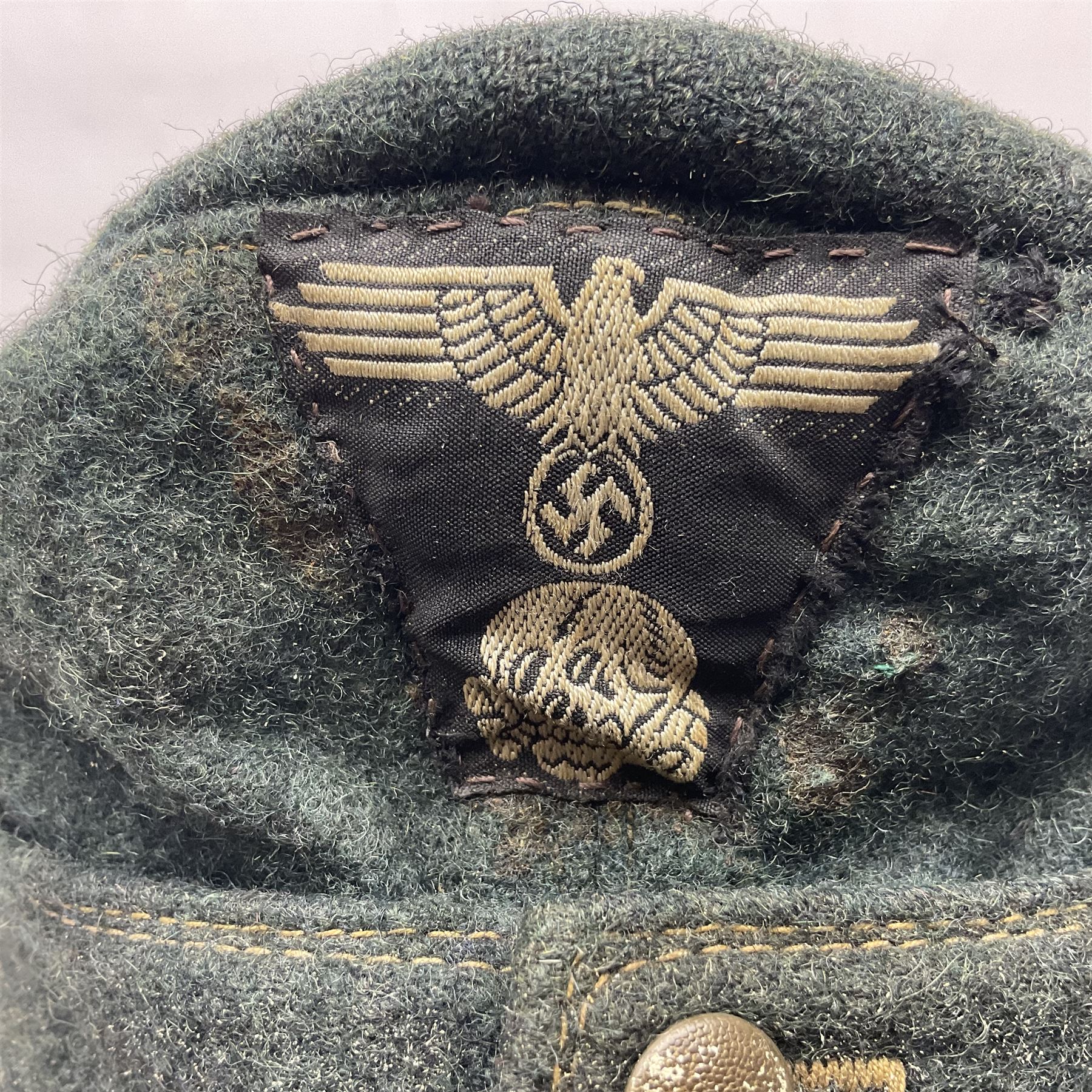 WWII German M43 field cap with 'SS' cloth badge and mountain trooper's edelweiss metal badge