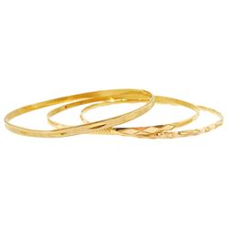 Three Middle Eastern gold bangles, with engraved decoration