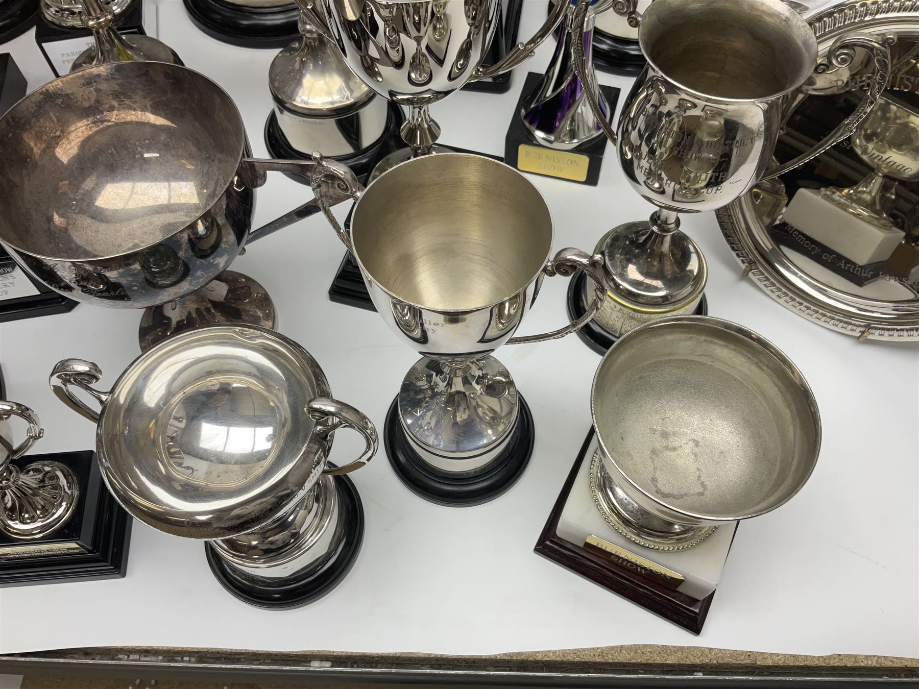 Collection of silver plated and metal trophy cups and winners plaques, all relating to the Burniston and District Show, most engraved with competitions and winner's names, in three boxes 