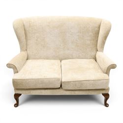 Parker Knoll - 'Hartley' lounge suite, comprising three wingback armchairs and two-seat settee, upholstered in cream fabric, shaped wing backs with scroll-over arms and loose seat cushions, on cabriole supports with pad feet wingbacks and settee

Armchairs: H 96cm, D 83cm, W 75cm