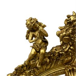 Large Italian Baroque design gilt wall mirror, the shell pediment over circular panel depicting classical female flute player with dancing putto within a tree landscape, the stepped arched upper frame surmounted by musical instrument playing putto and trailing flower heads, central bevelled mirror plate surrounded by plain segmented mirror plates, acanthus leaf moulded outer frame and foliate moulded inner slip