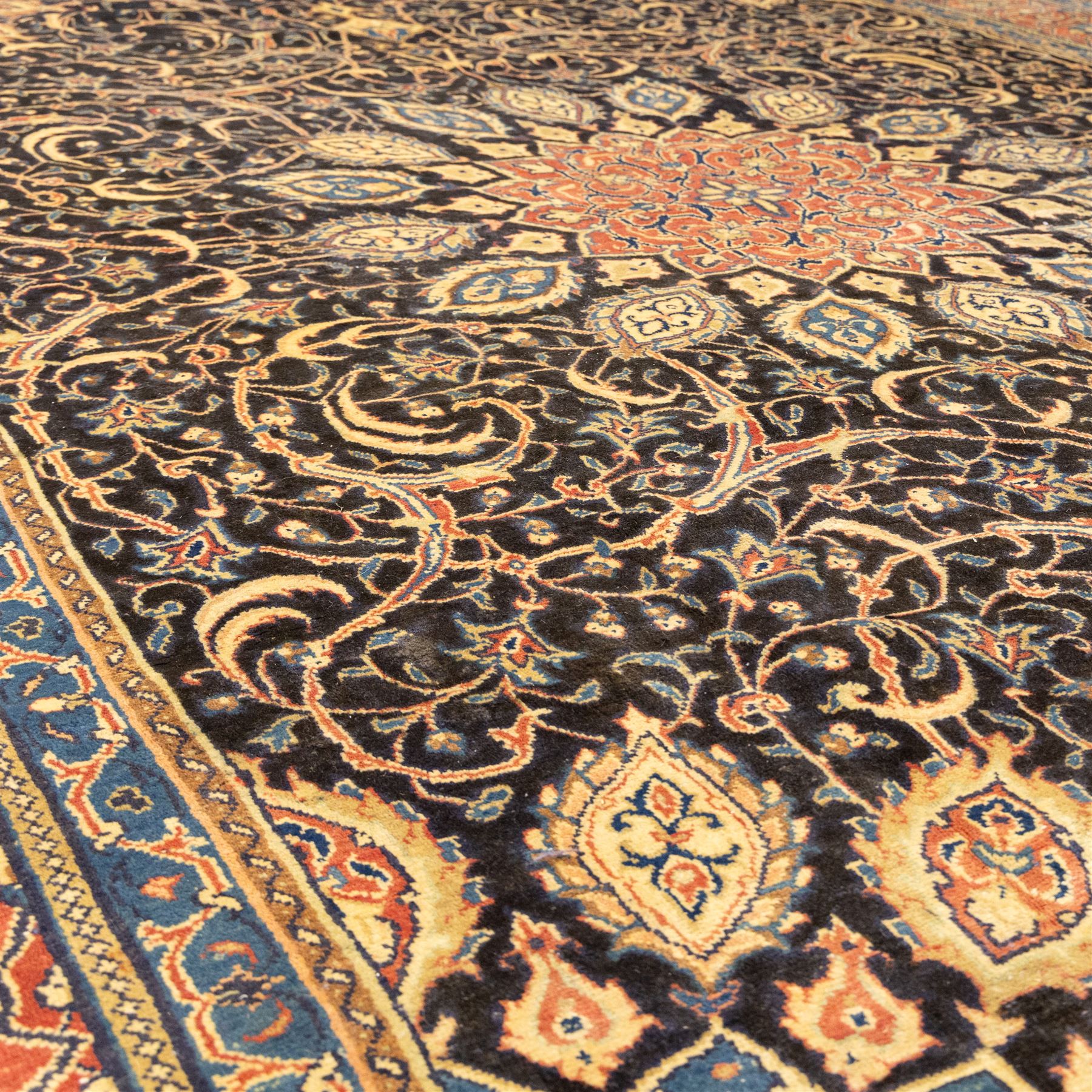 Large North West Persian Mahal hand-knotted carpet, central indigo field with a rosette medallion with an all-over design of scrolling vines and palmettes, framed by a brick red border of arabesques and flowerheads between sky blue and ivory guard stripes, with cotton fringe ends 