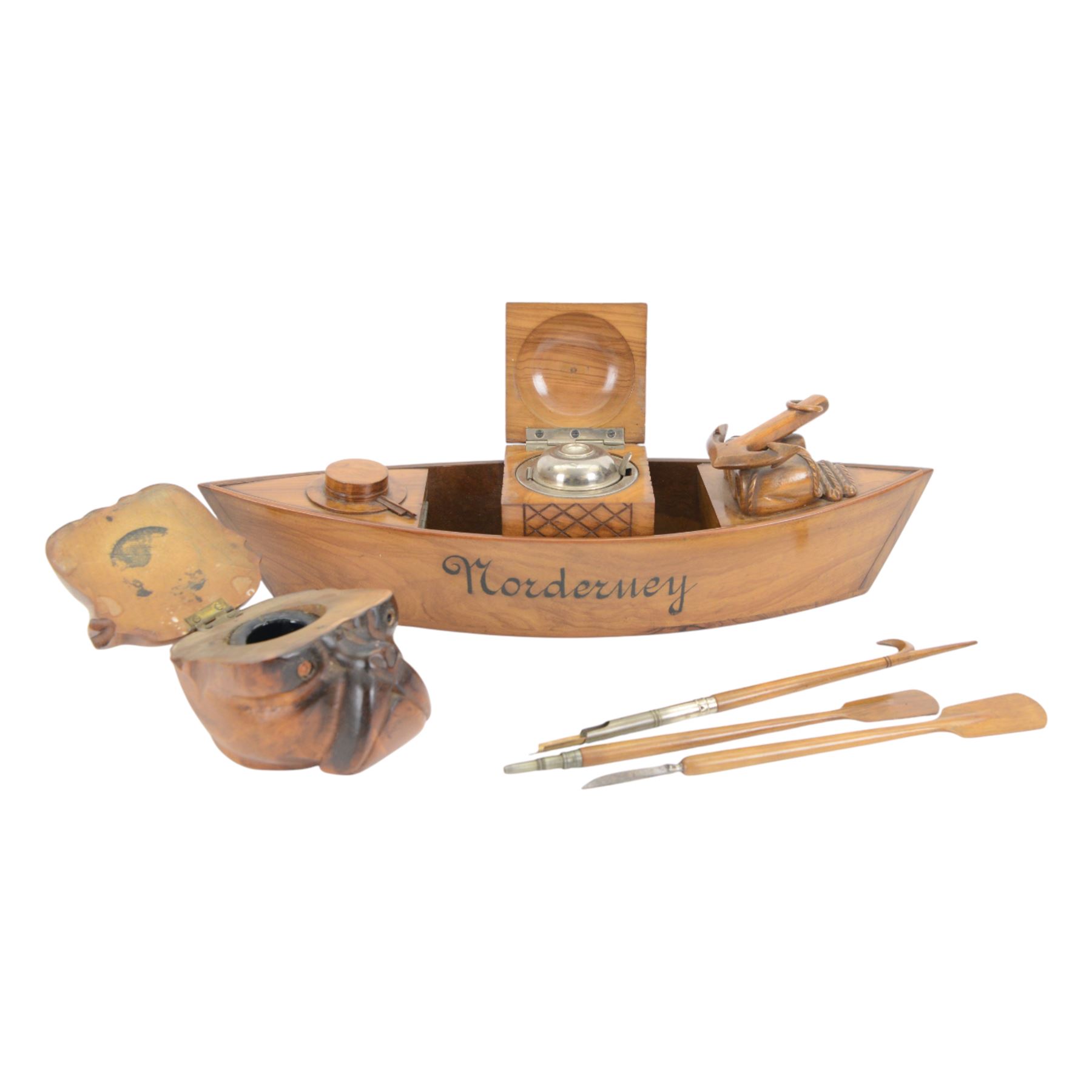 Novelty desk inkwell formed as a boat, with central chimney opening to reveal a metal inkwell with two pens formed as oars, together with another inkwell in the from of a bull dog 