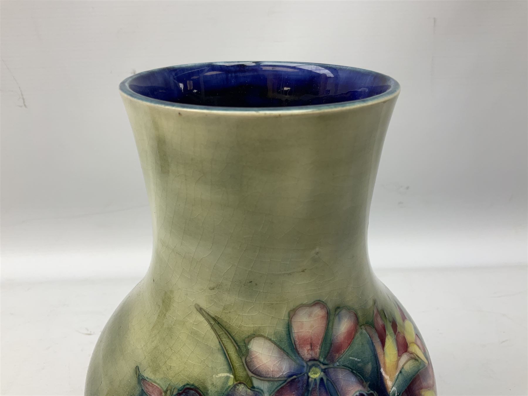 Moorcroft vase of baluster form decorated in the Spring Flowers pattern upon a merging green and blue ground, with impressed and painted marks beneath, H22.5cm