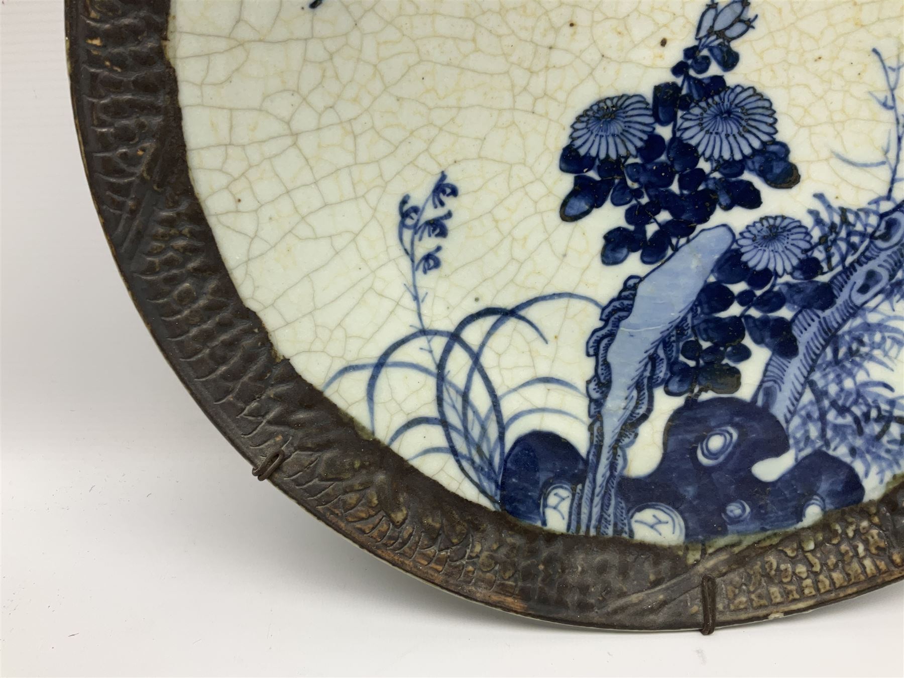 20th century Chinese blue and white crackle glaze charger, decorated with peonies, prunus blossom, and rockwork, within simulated bronze border, with character mark verso, D34cm