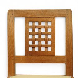 Mouseman - set of eight (7 + 1) oak dining chairs, pierced and carved lattice back over leather upholstered seat, on octagonal front supports united by stretchers, carved with mouse signature, by the workshop of Robert Thompson, Kilburn