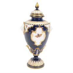 Late 19th century Royal Worcester porcelain vase and cover, circa 1897, of baluster form with twin lion masks to shoulders, painted with a reserve of exotic birds within a landscape, against a blue scale ground with gilt highlights, and further detailed with smaller reserves containing butterflies, the shoulder, base of body and foot with moulded acanthus bands, upon a circular spreading foot, with green printed marks beneath including shape number 2305 and Rd no 419210, H27.5cm