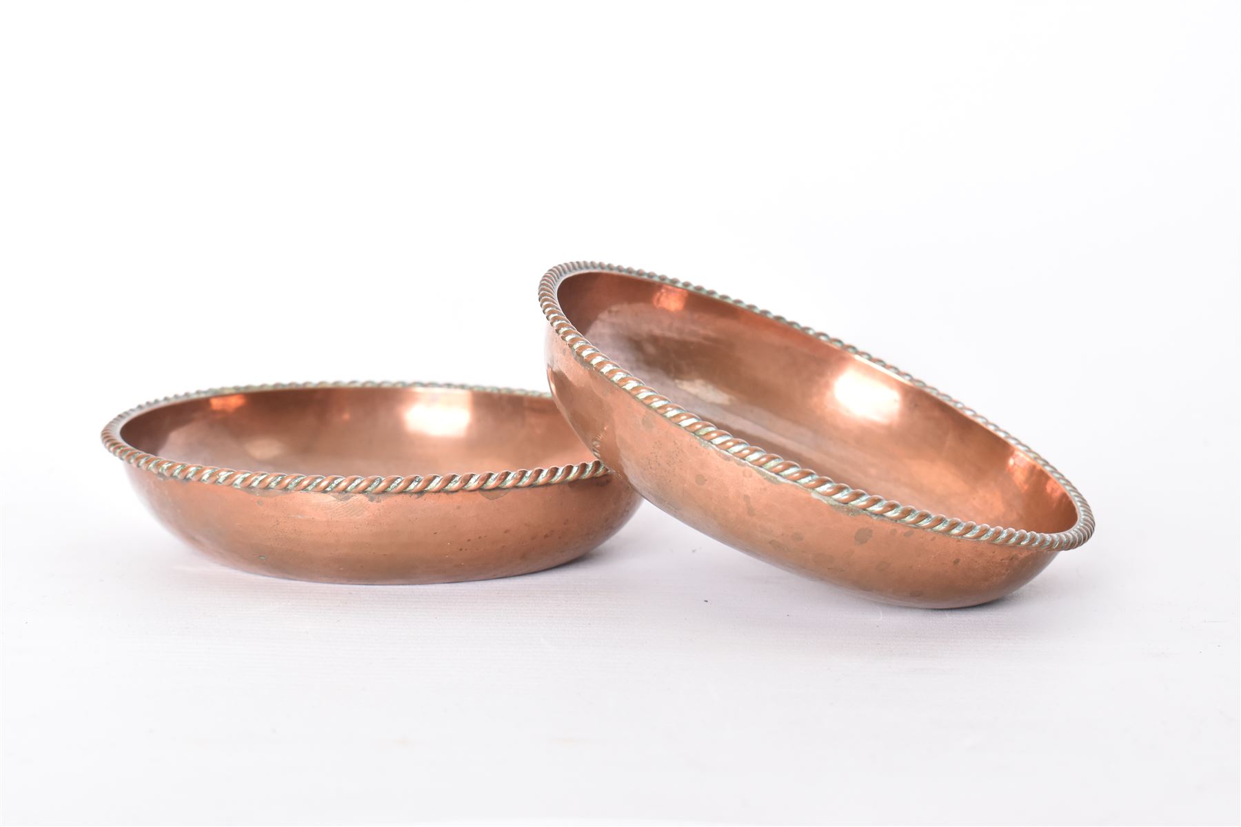 Pair of Arts & Crafts copper dishes by Gordon Russell, with lightly hammered finish and oblique gadrooned rim, impressed beneath 'Golf Hotel Grange Over Sands' and with maker's mark for Lygon
