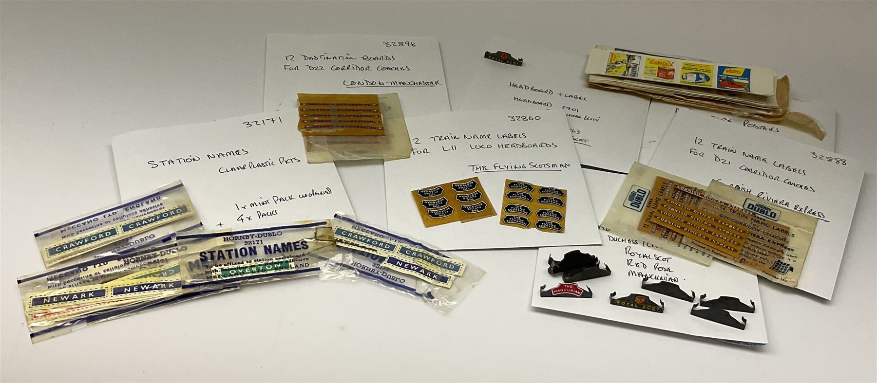 Hornby Dublo etc - large quantity of labels etc comprising headboards and train names including Mallard, Mancunian, Bristolian, Royal Scot, Flying Scotsman, Red Rose, White Rose, etc; destination boards for corridor coaches; station names; miniature posters; insulating tabs; lubricating oil etc; many in original packets.