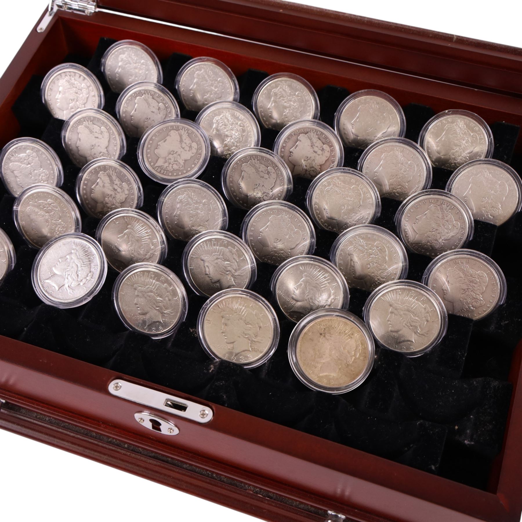 Thirty-two United States of America silver one dollar coins, comprising twenty-three 'Morgan' dollars and nine 'Peace' dollars, presented as 'The Complete Morgan and Peace Silver Dollar Collection', in display case