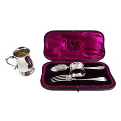 Matched silver christening set including George III spoon by Thomas Wallis II, London 1795, George IV fork London 1825 and Victorian napkin ring by Charles Stuart Harris, London 1886, all bright cut floral decoration, in fitted velvet and silk lined case and a silver christening mug by William Comyns & Sons Ltd, London 1929, approx 5.2oz 