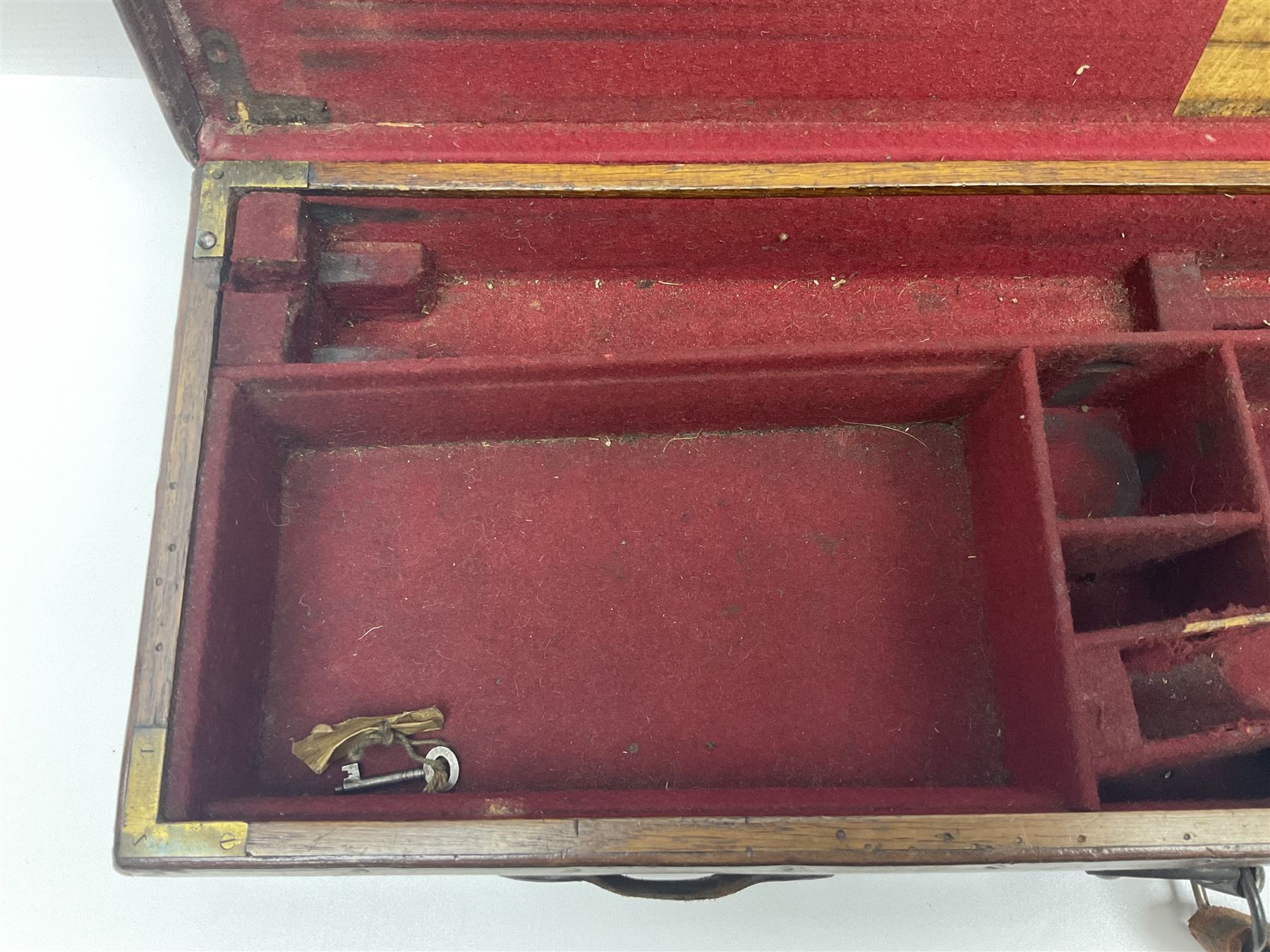 Leather shotgun case, the red baize lined interior with the trade labels of Westley Richards & Co., London, a brass plaque inscribed 'T Nevin, Mirfield, Yorkshire' to cover, with key, case to fit barrel 76cm (30 inches)  
