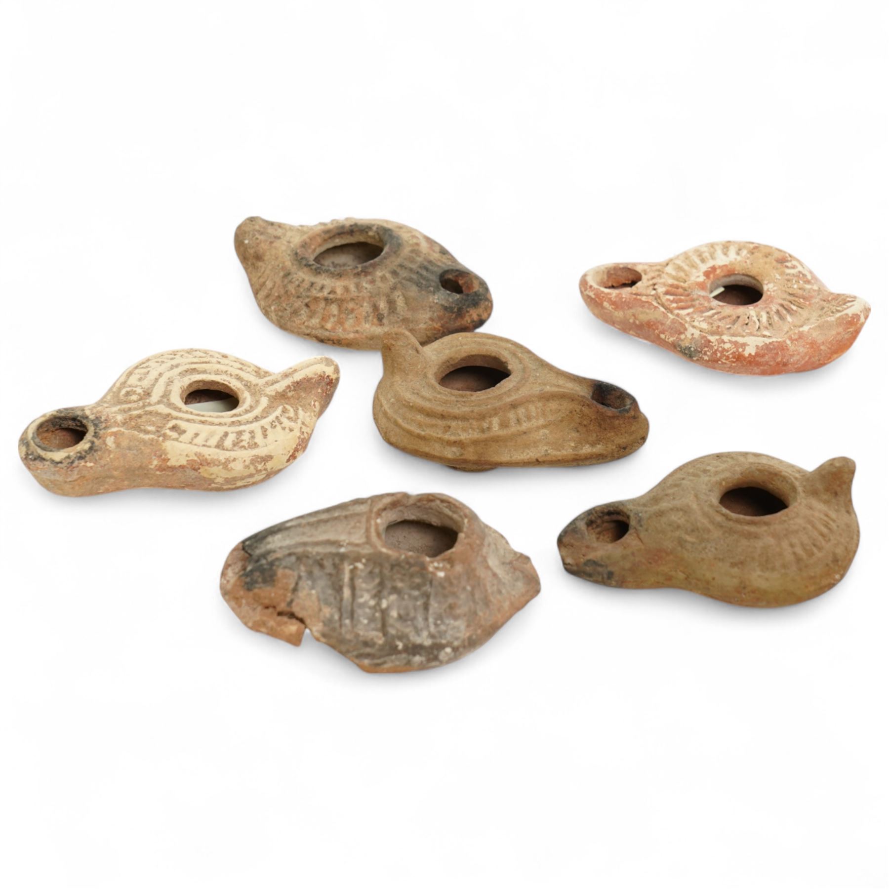 Antiquities; six Byzantine oil lamps, including terracotta examples, approximately 5th-7th century, having incised decoration, largest W10cm (6)