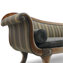 Regency brass inlaid rosewood chaise lounge or settee, shaped back over rolled head and foot, upholstered in black and gold striped fabric with rectangular squab cushion and bolster cushion, the rolled terminals carved with acanthus leaf roundels, lower rectangular foliate carved panels, on out splayed supports with paw carved feet 